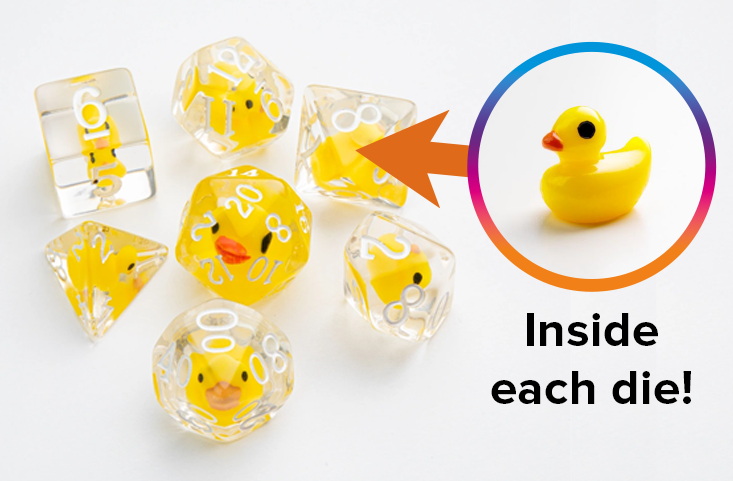 An overhead photo of seven Embraced Dice from Gamegenic, and a close up of a rubber duck token that is embedded in the center of each die.